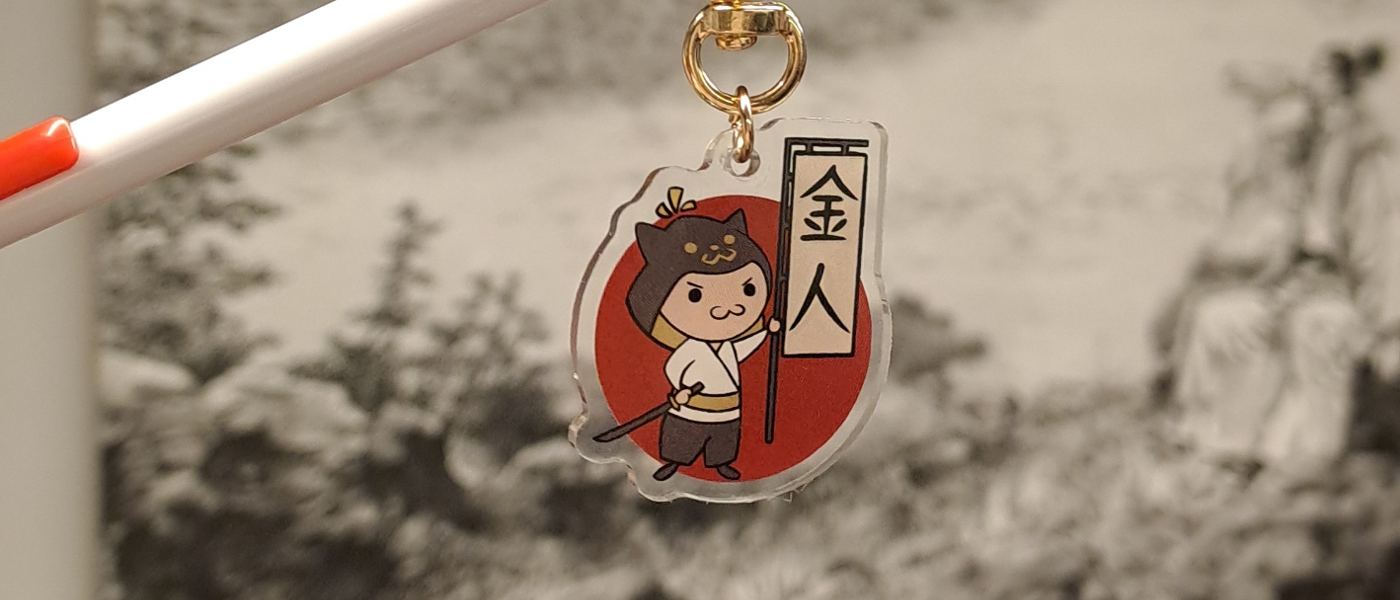 A picture of an acrylic keychain charm with Kinjin's logo on it